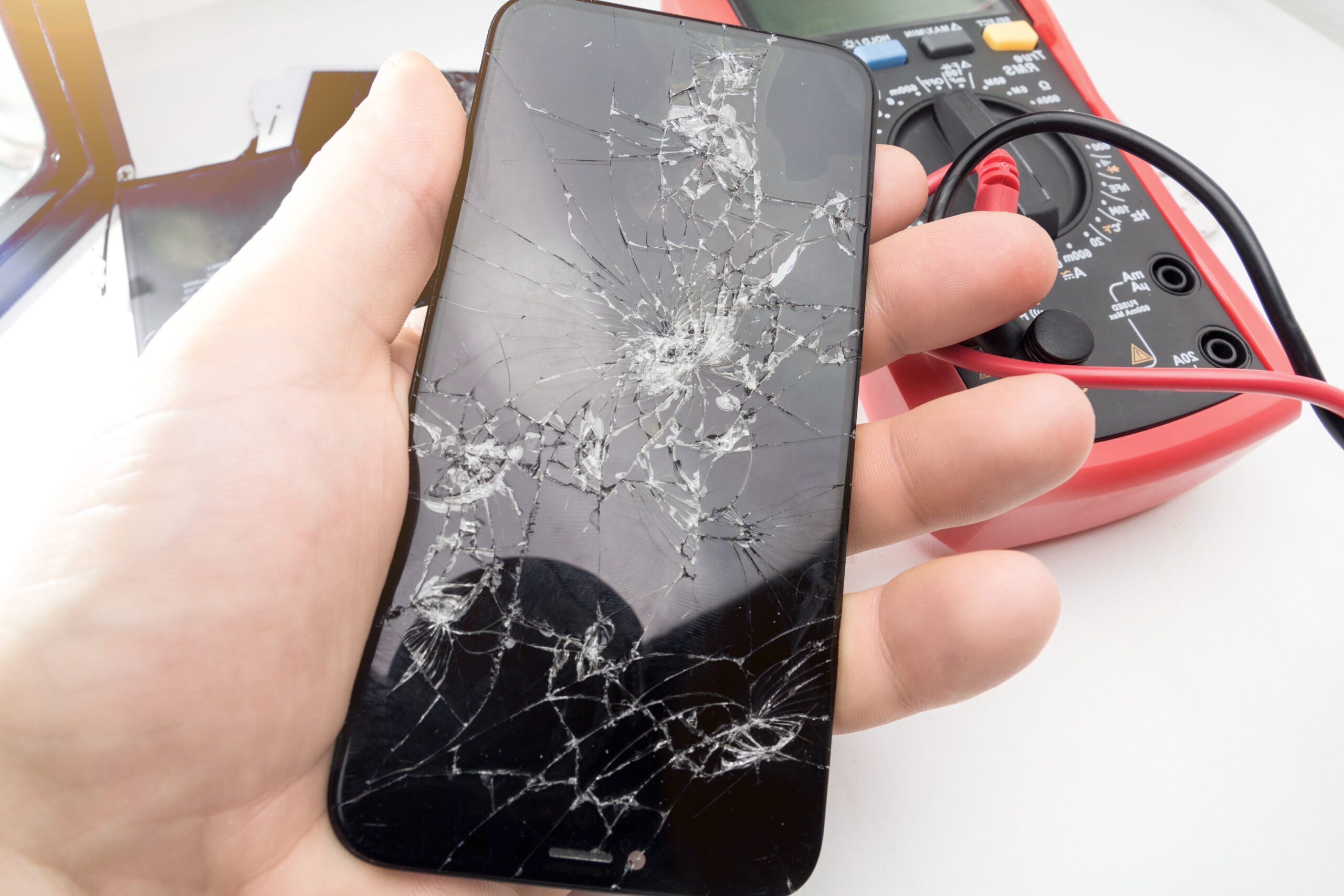 male hand holding broken smartphone broken mobile phone lcd screen scaled